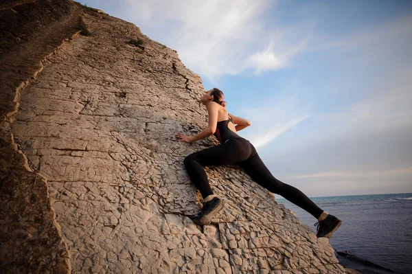 Athletic young pretty girl rock climbing without carbines and rope, bouldering. — Stock Photo, Image
