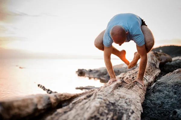 Postura del yoga del handstand por el hombre en la playa cerca del océano —  Fotos de Stock