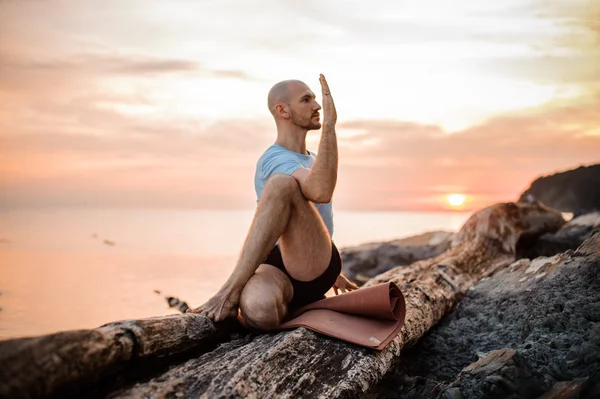 Sitter man gör yoga på stranden av oceanen, — Stockfoto