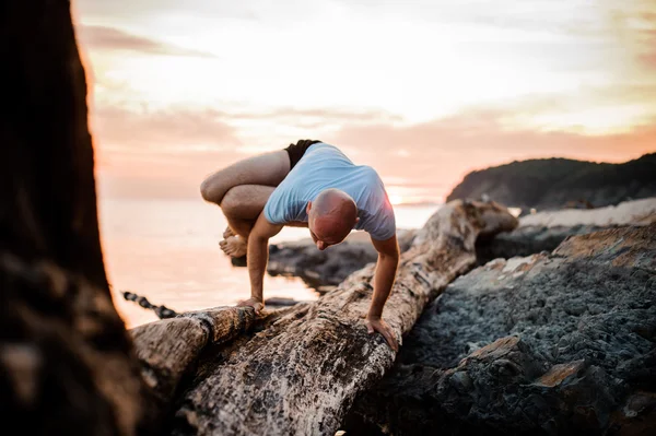 Postura del yoga del handstand por el hombre en la playa cerca del océano — Foto de Stock