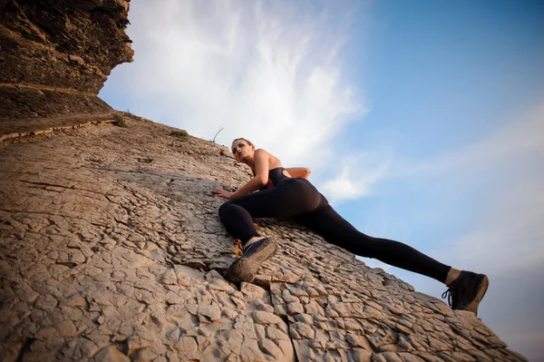 바위 위를 오르는 젊은 여자. — 스톡 사진