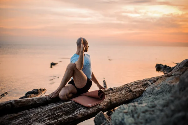 Sitter man gör yoga på stranden av oceanen, — Stockfoto