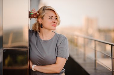 Çatı üstüne duran güzel sarışın kadın.