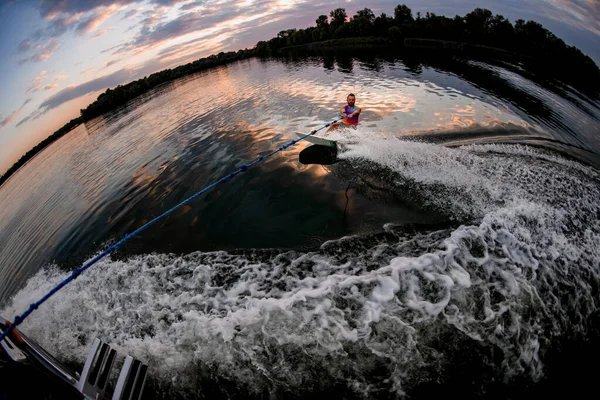 Visão de alto ângulo do homem segurando corda e montando wakeboard na onda de lancha — Fotografia de Stock