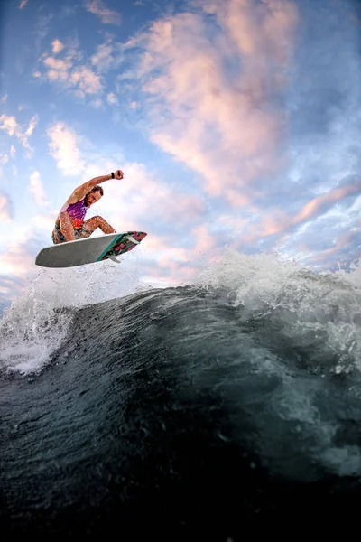 Vista de esportes cara equitação onda fazendo saltos e truques no wakeboard estilo surf — Fotografia de Stock