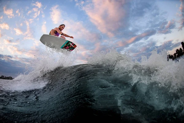 Ottima vista dell'onda su cui l'uomo sportivo salta sul wakeboard in stile surf. — Foto Stock