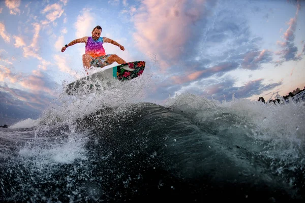スポーツマンがサーフスタイルのウェイクボードでジャンプする波の美しい景色. — ストック写真