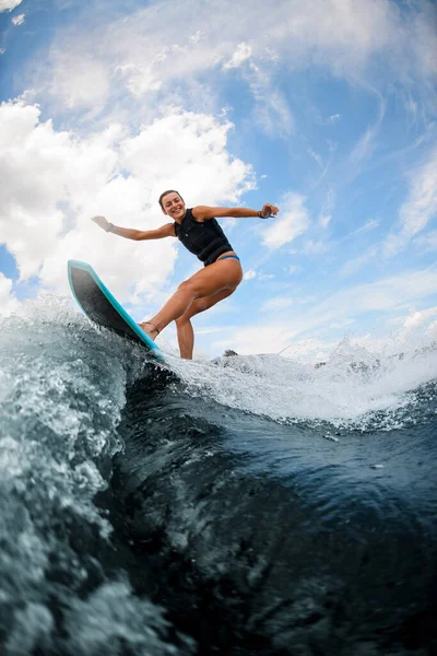 Sporty woman having fun and jumping on the board on the river — Stock Photo, Image