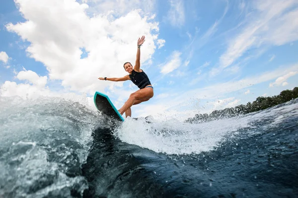 Femme sportive sportive et active sautant sur la planche sur la rivière — Photo