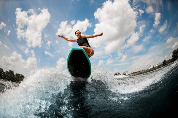Спортсменка в плавальному жилеті розважається і стрибає на дошці на річці — стокове фото