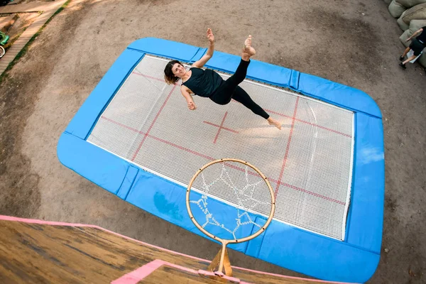 Zicht op jonge vrolijke vrouw springen op trampoline. — Stockfoto