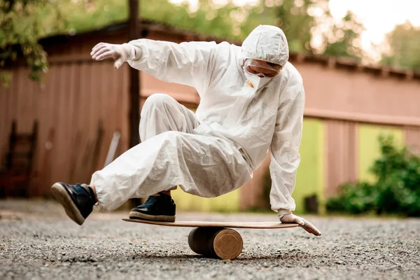 Homem em terno protetor branco com capuz está equilibrando a bordo. — Fotografia de Stock