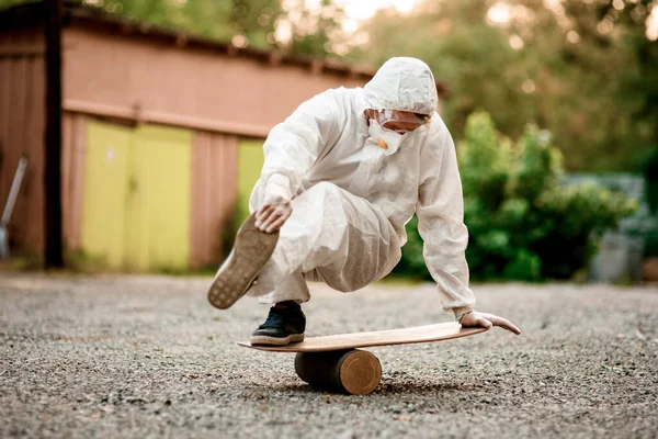 Zicht van de mens in wit beschermend pak voert truc op de balance board — Stockfoto