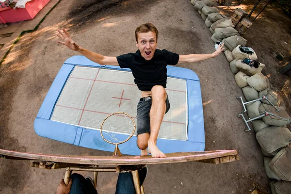 Überraschter springt hoch auf Trampolin und berührt Basketballständer mit den Füßen — Stockfoto