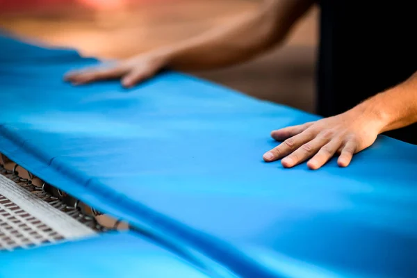 Närbild av unga män händer som ligger på blå yta av studsmattan — Stockfoto