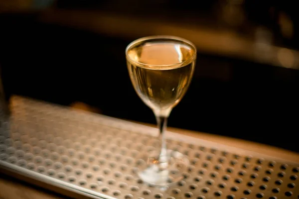 แก้วไวน์โปร่งใสพร้อมเครื่องดื่มแอลกอฮอล์ยืนอยู่บนเคาน์เตอร์บาร์ — ภาพถ่ายสต็อก
