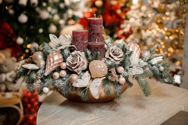 Ağaçtan oyuncaklarla süslenmiş mumlarla süslenmiş güzel bir Noel kompozisyonu ve parıltılı güller.