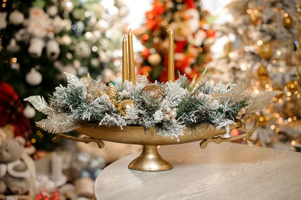 Arranjo de inverno magnífico de ramos de abeto com velas e brinquedos de árvore em vaso dourado. — Fotografia de Stock