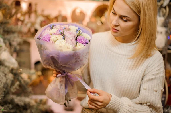 Szőke nő virágüzlet szépen nyakkendő szalagban finom csokor friss virág. — Stock Fotó