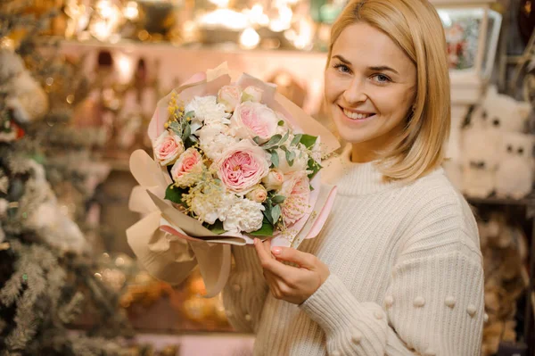 Sonriente mujer sosteniendo hermoso delicado ramo rosa de rosas frescas de peonía en su mano — Foto de Stock