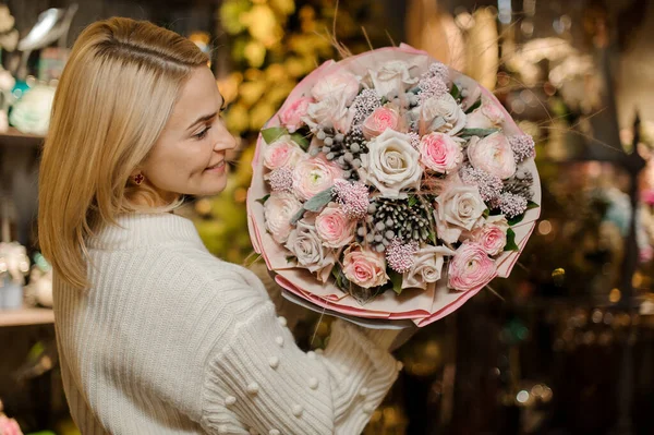 Mujer guapa sostiene muy hermoso ramo grande de rosas en sus manos — Foto de Stock