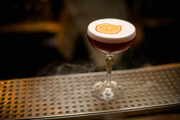 Detailní záběr sklenice s pěnou a plátkem citrusových stojanů na baru — Stock fotografie