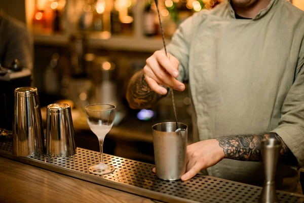 Barman sosteniendo la cuchara larga del bar y revolviendo cóctel en taza de mezcla — Foto de Stock