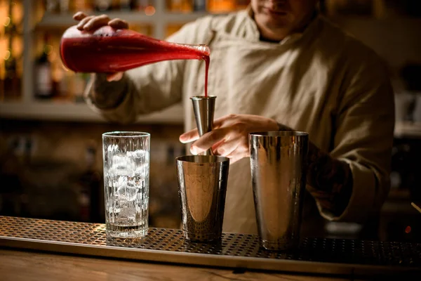 Barman precisa vierte bebida roja de botella en jigger metal — Foto de Stock