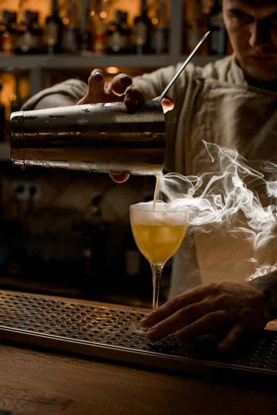Barmann gießt dampfenden Drink aus Shaker-Becher vorsichtig in Weinglas — Stockfoto