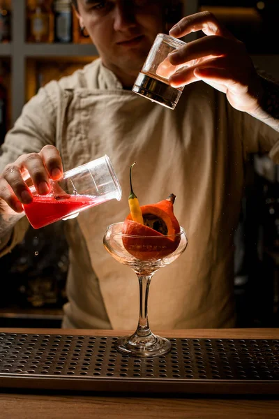 Barman añadir ingredientes al vidrio con calabaza pequeña y pimienta en el interior — Foto de Stock