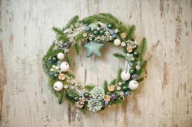 Yeşil ladin dalları, çam kozalakları, böğürtlen ve oyuncaklarla süslenmiş zarif Noel çelengi..