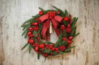 Parlak kırmızı böğürtlenlerle süslenmiş köknar ağacından güzel bir çelenk.