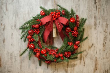 Parlak kırmızı böğürtlenlerle süslenmiş köknar dallarından oluşan muhteşem Noel çelengi.