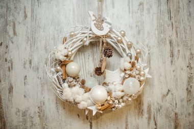 Beyaz toplar, kozalaklar, tarçın çubukları ve pamuk çiçekleriyle süslenmiş güzel bir Noel çelengi..