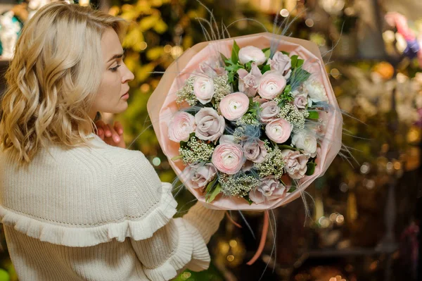 Vista trasera de mujer bonita sosteniendo delicado ramo rosa de rosas en su mano —  Fotos de Stock