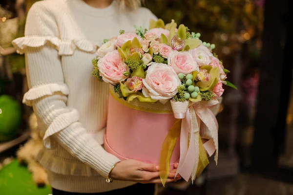 Composição bonita de flores rosa frescas em caixa redonda em mãos de mulher. — Fotografia de Stock