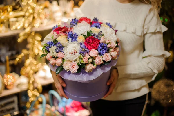Arreglo de flores de diferentes flores en caja redonda de color lila grande en mano de mujer — Foto de Stock