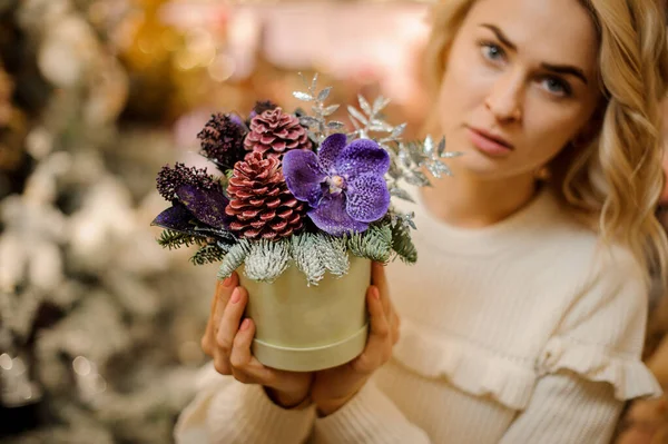 Δημιουργική σύνθεση λουλουδιών σε στρογγυλό κουτί στα χέρια της ξανθιάς γυναίκας — Φωτογραφία Αρχείου