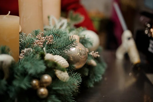 Крупным планом еловых ветвей, украшенных блестящими рождественскими игрушками и свечами — стоковое фото