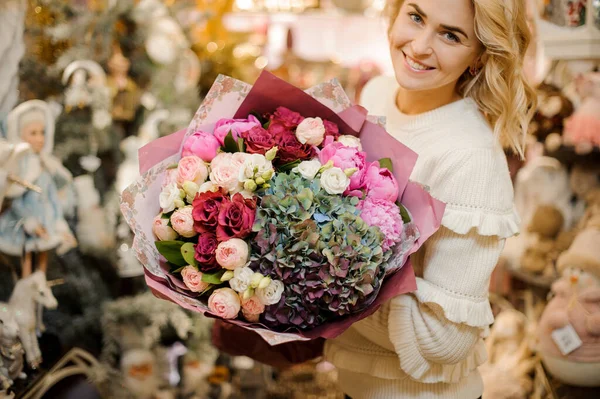 luxury bouquet of fresh flowers of hydrangea and roses and peonies in hands of woman