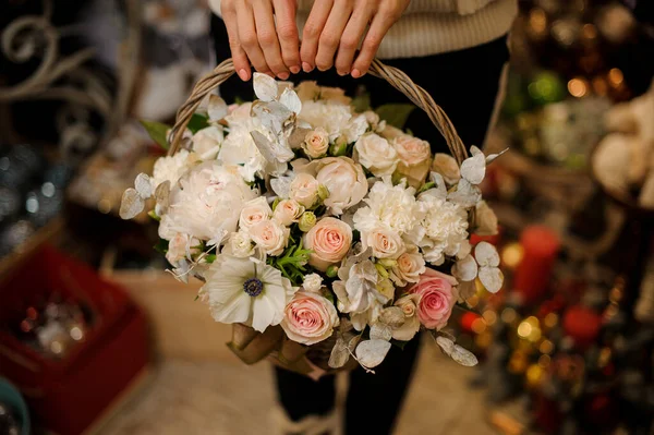 Primer plano de ramo de diferentes flores de crema en canasta de mimbre en manos femeninas — Foto de Stock