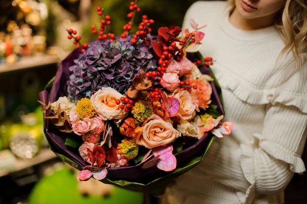 Precioso ramo floral de rosas y hortensias púrpura en las manos de las mujeres — Foto de Stock