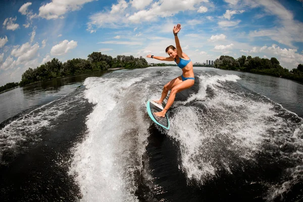 Aktív atlétikai nő kiegyensúlyozó a ébrenléti fedélzeten a nagy hullámú motorcsónak — Stock Fotó