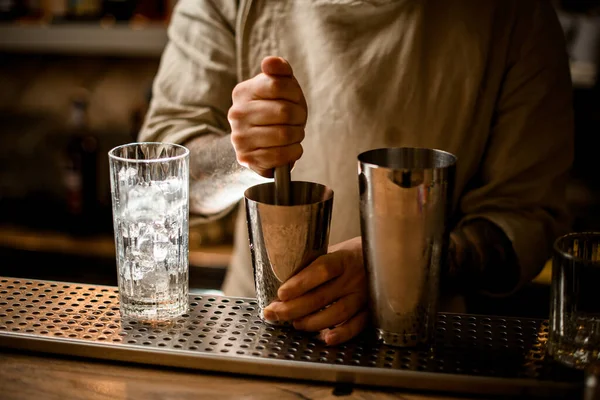Camarero prepara cóctel en la taza de coctelera utilizando el muddler — Foto de Stock