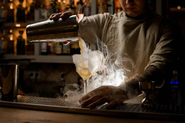 Vista del barman versare bevanda fumante dalla tazza shaker in bicchiere di vino — Foto Stock