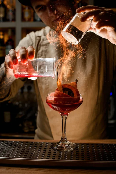 Uomo barista preciso aggiungere ingredienti al vetro con verdure all'interno e fa fuoco su di esso — Foto Stock