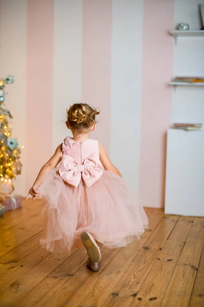 Vista trasera de longitud completa de niña en hermoso vestido rosa con lazo atado — Foto de Stock