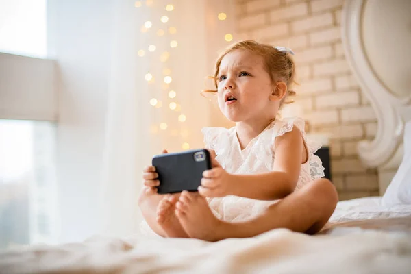 Ver en niña con expresión disgustada celebración de teléfono móvil — Foto de Stock