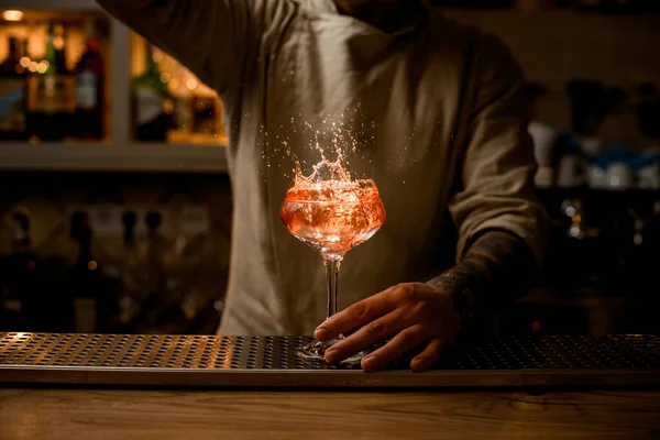 Bicchiere di vino con spruzzi di cocktail luminoso che si trova sul bancone del bar. — Foto Stock