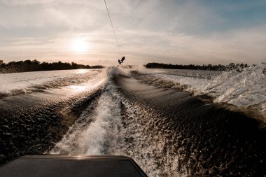 Dalgalar üzerinde zıplayan erkek wakeboardcunun görüntüsü